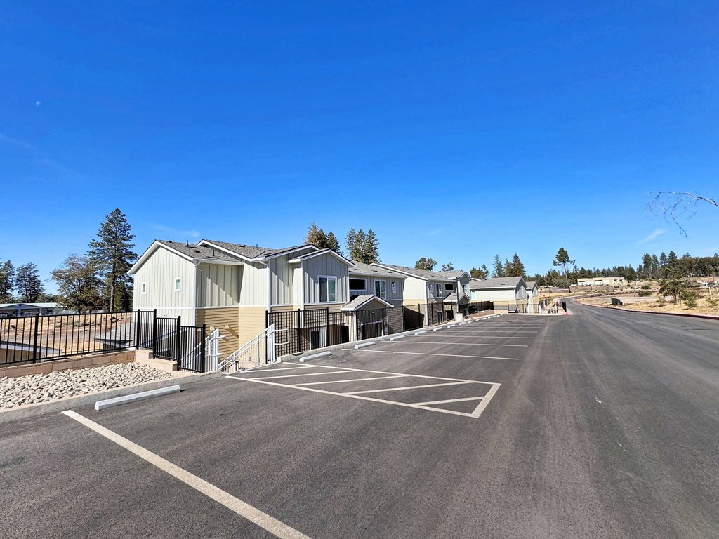 a parking lot with houses on the side of a road