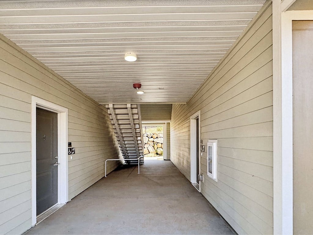a hallway of a house with stairs and a door