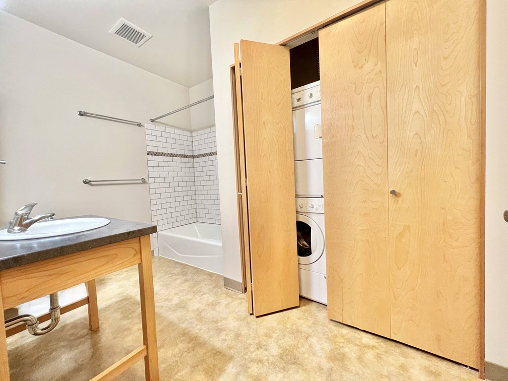 a bathroom with a washer and dryer in a closet next to a sink