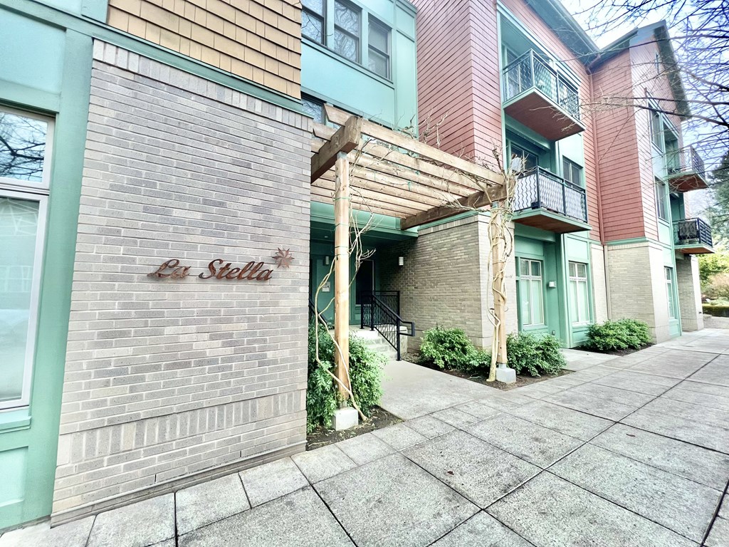 the side of a building with a sidewalk in front of it