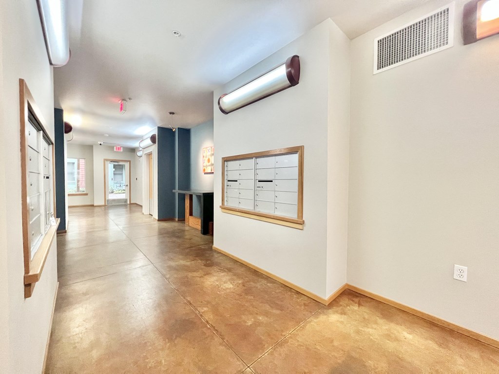 a hallway with a bulletin board on the wall and a hall way with a door