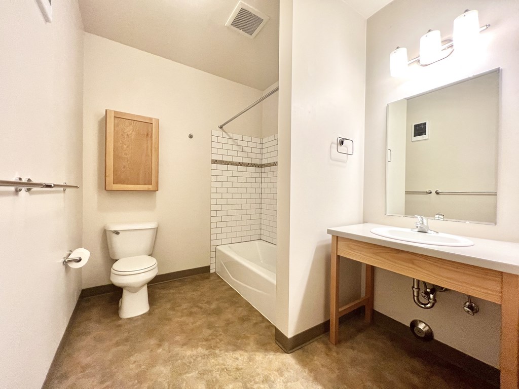 a bathroom with a toilet sink and shower and a mirror