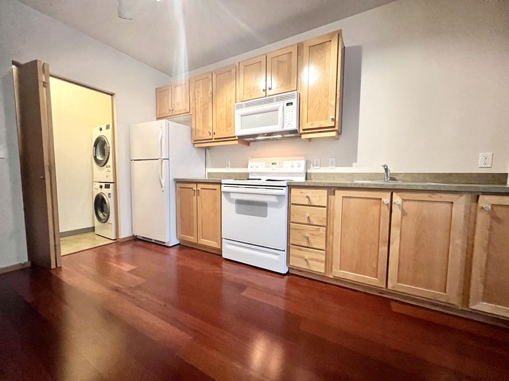 an empty kitchen with wooden floors and wooden cabinets
