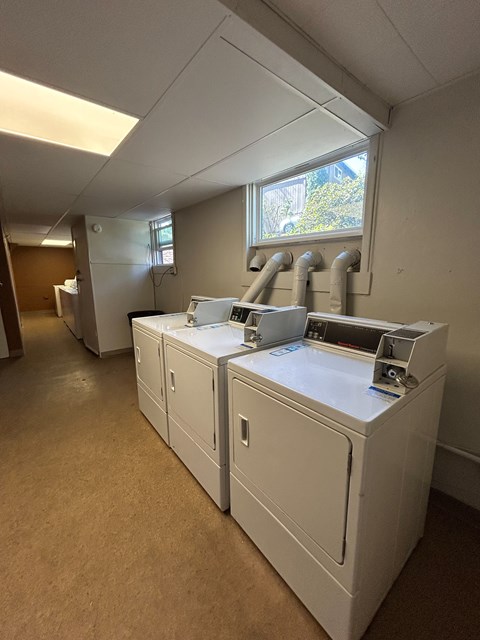 A laundry room with washers and dryers.