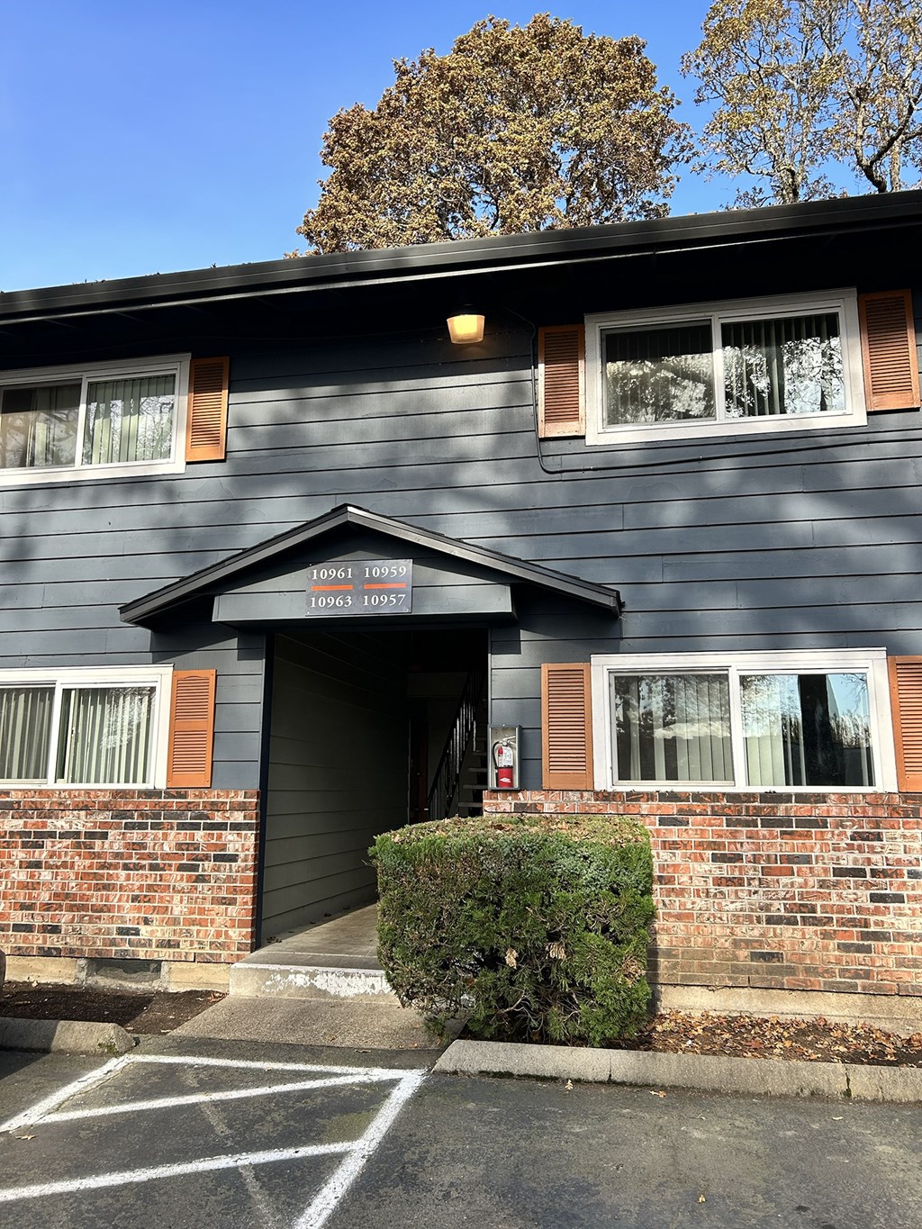 A grey building with a black roof and a sign on the front.