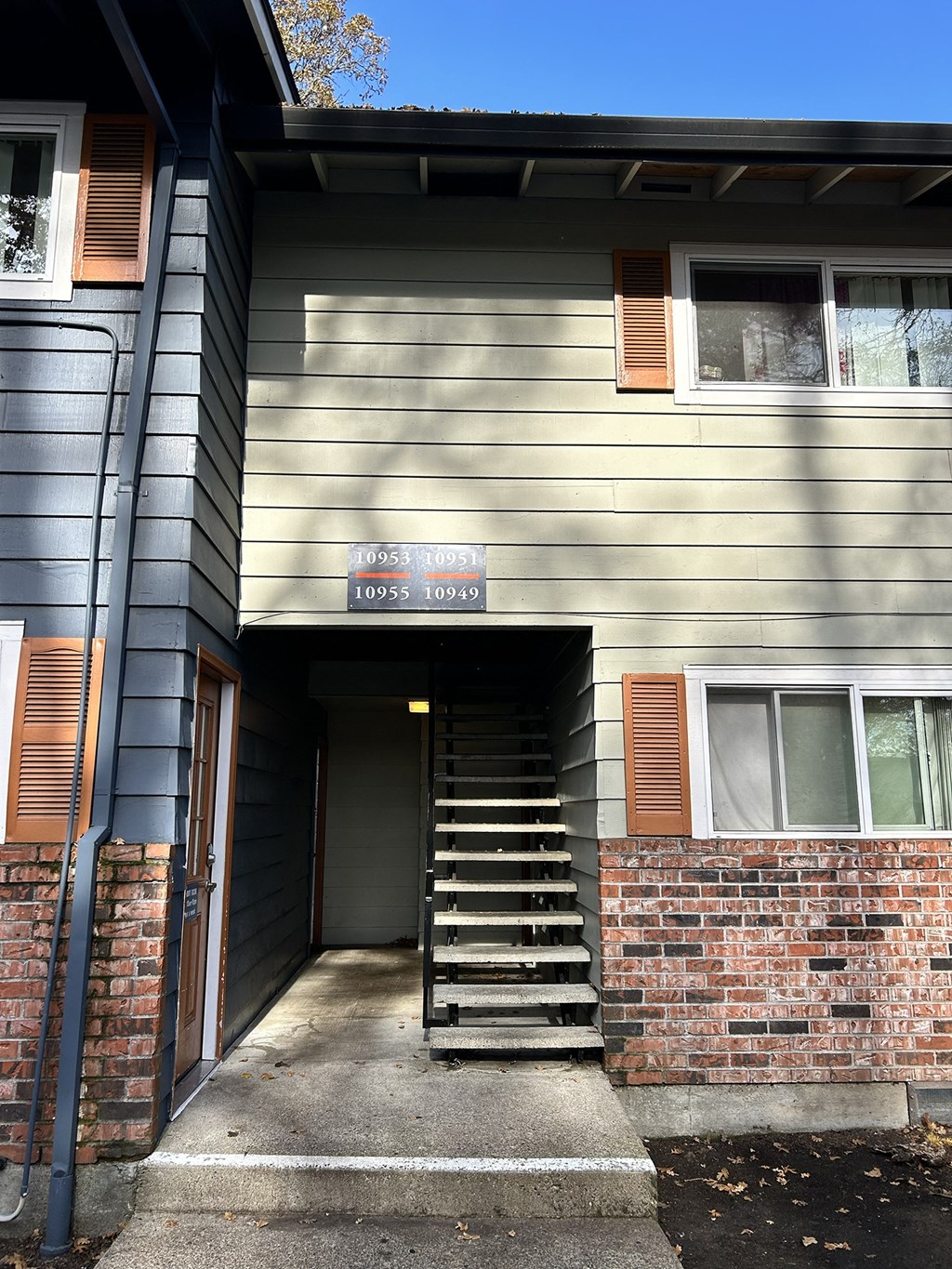A house with a grey siding and a brown door.