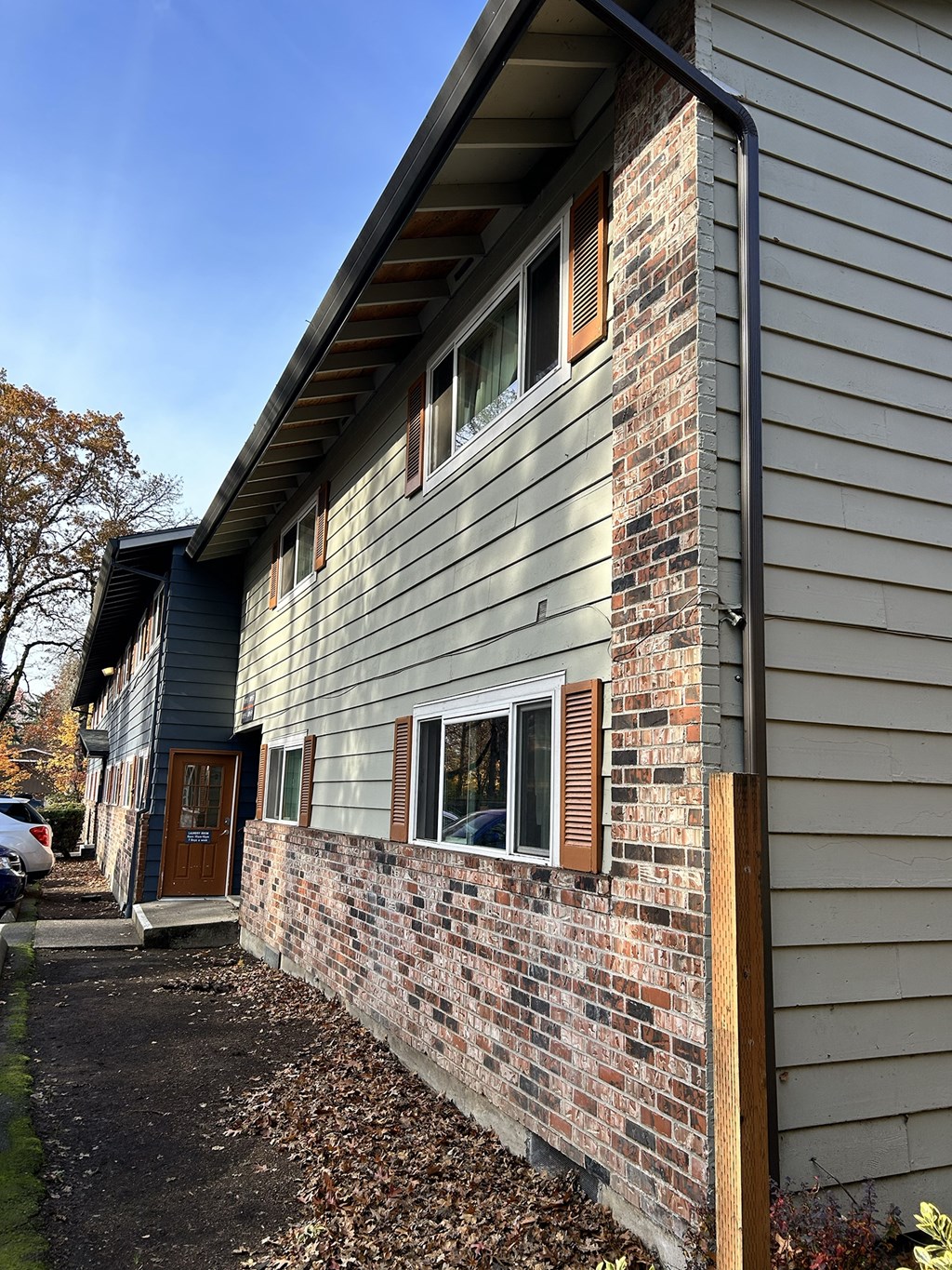 A house with a grey siding and a brick chimney.
