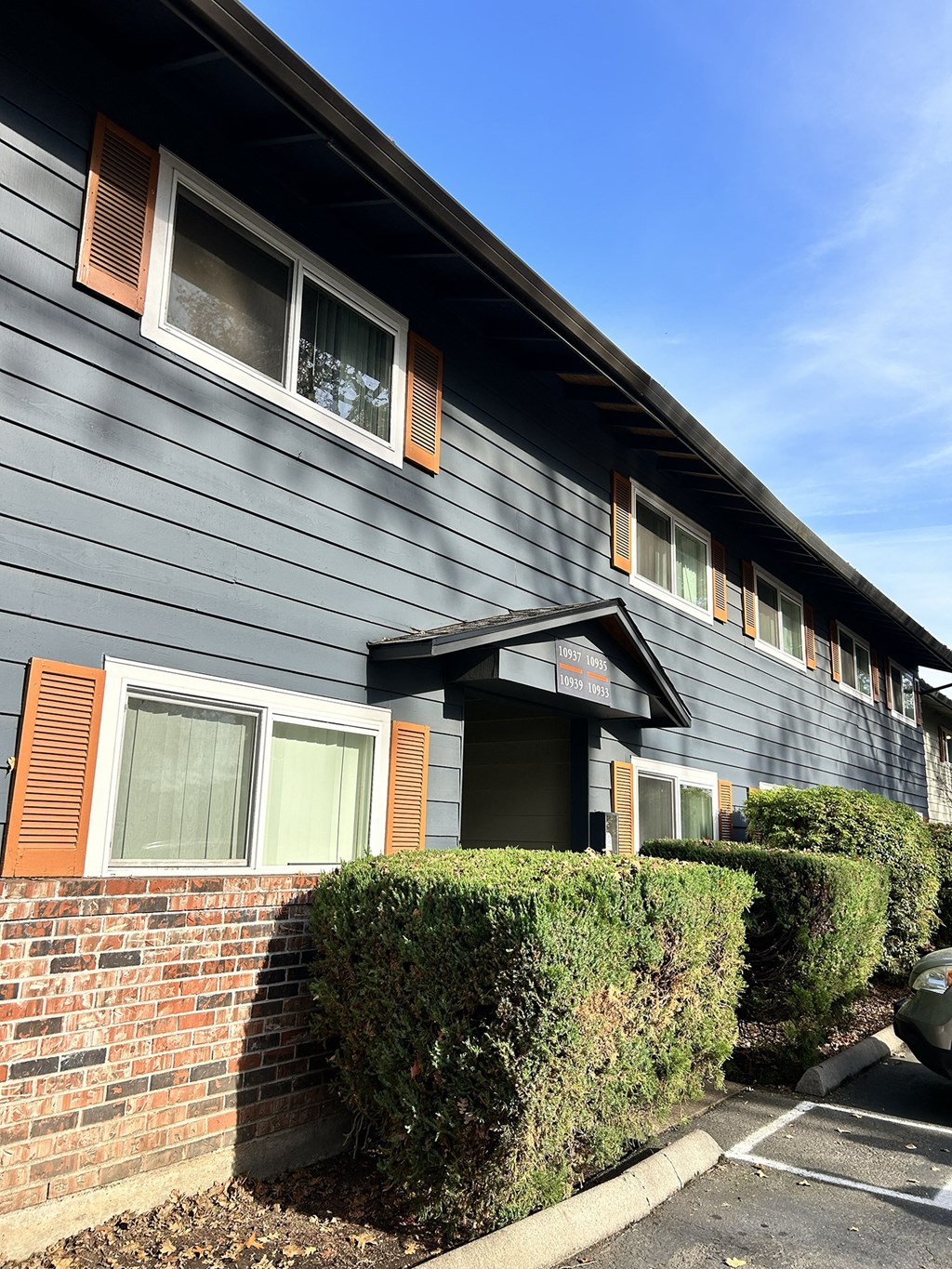 A building with a grey facade and a brick wall.