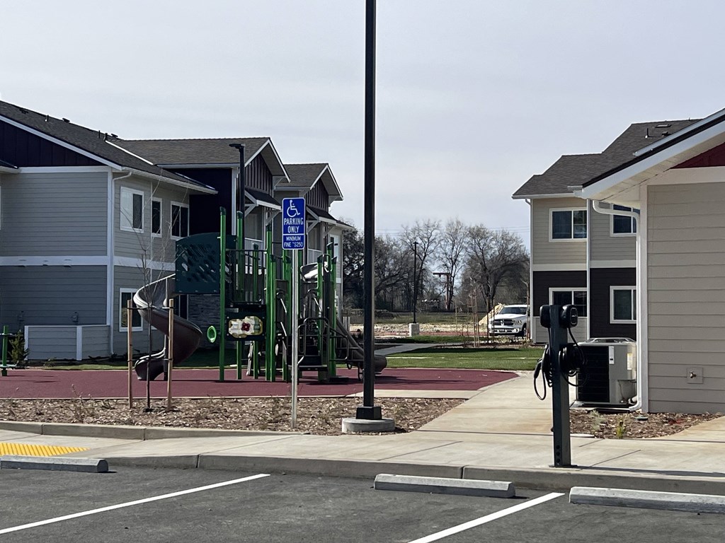 A parking lot with a handicap sign and a parking meter.