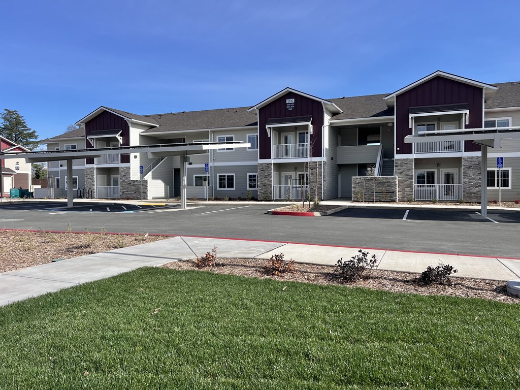 A large apartment complex with multiple buildings and a parking lot in front.