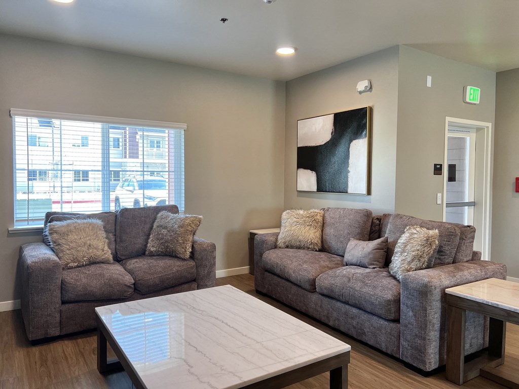 A living room with two grey couches and a white coffee table.