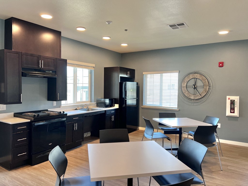 A kitchen with a table and chairs in front of it.
