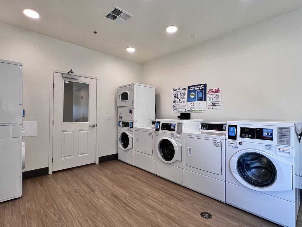 A laundry room with a stack of washers and dryers.