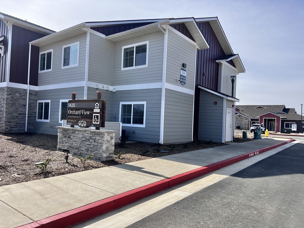 A modern two-story building with a stone pillar in front and a sign that reads "M45 Ochre View Terrace".
