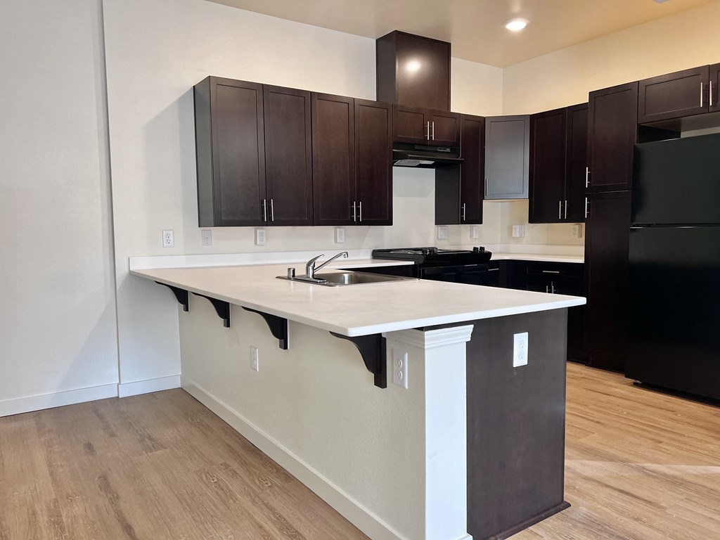 A kitchen with dark brown cabinets and a white island.