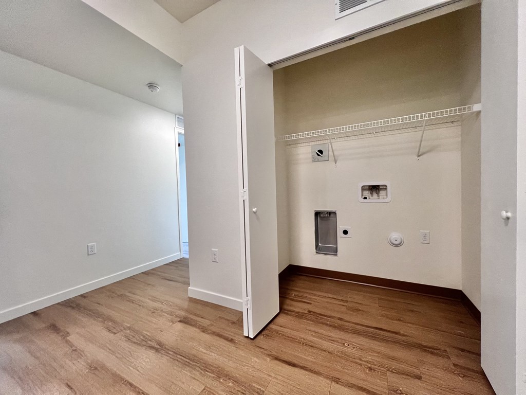 A room with a white door and a brown floor.