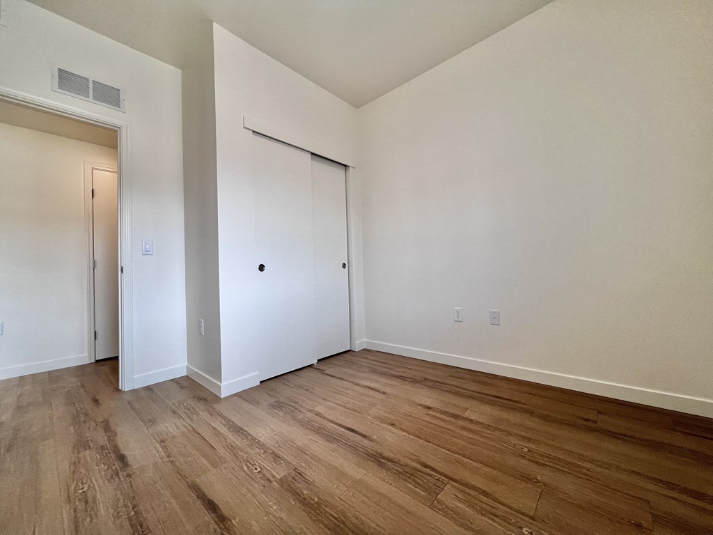 A room with a white wall and a wooden floor.