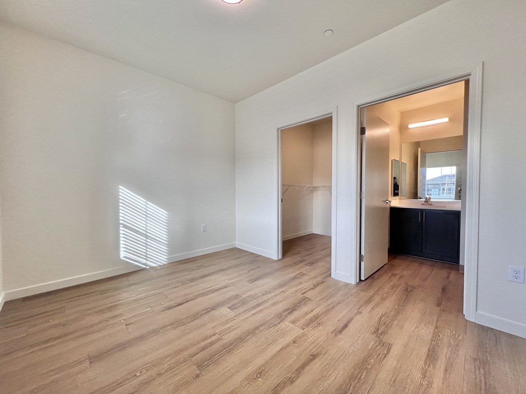 A room with wooden flooring and white walls.