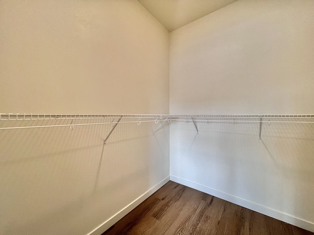 Empty room with white walls and wooden floor.