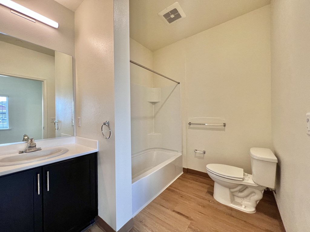 A bathroom with a white toilet, sink, and bathtub.