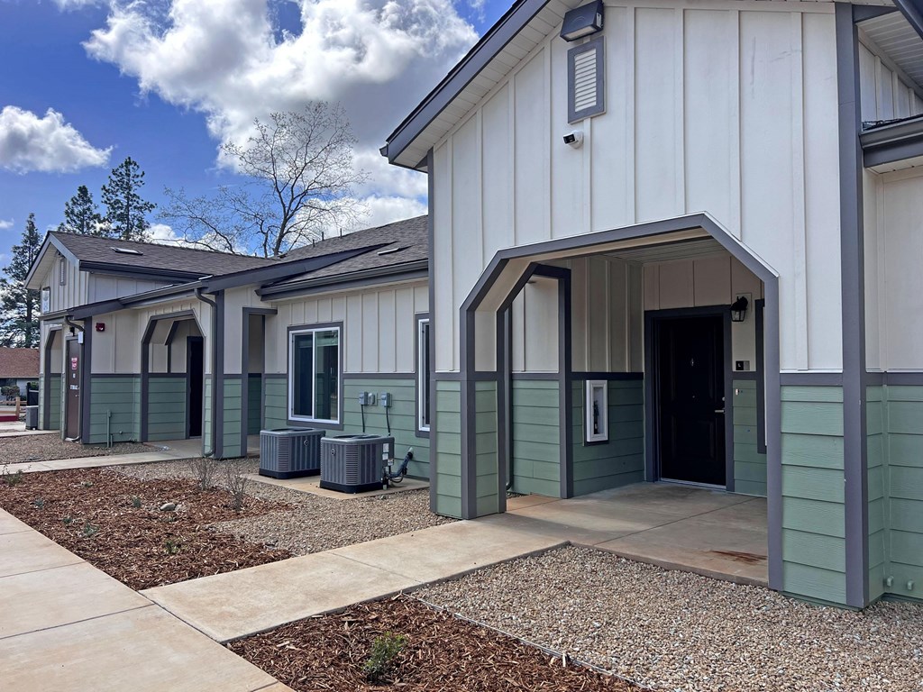 A row of houses with a gravel driveway in front.