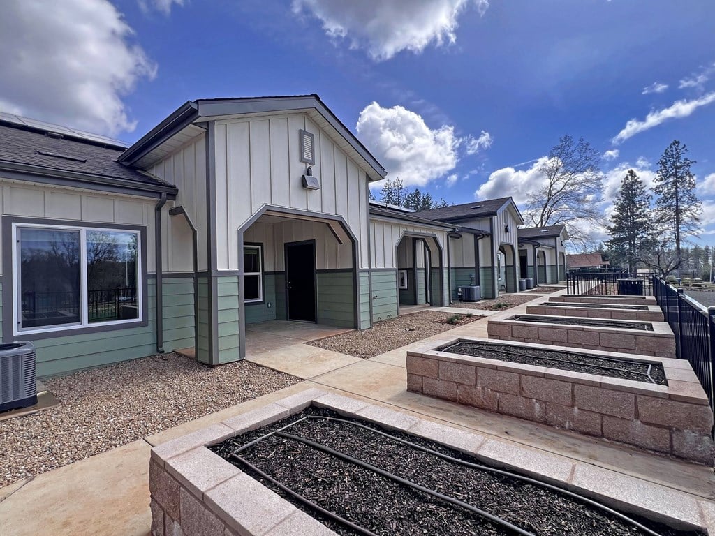 A series of small houses with a train track in the foreground.