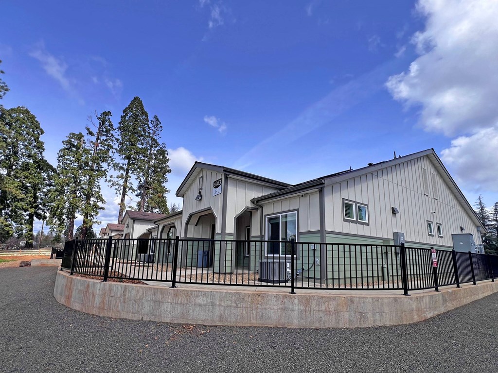 A house with a grey roof and a black fence.