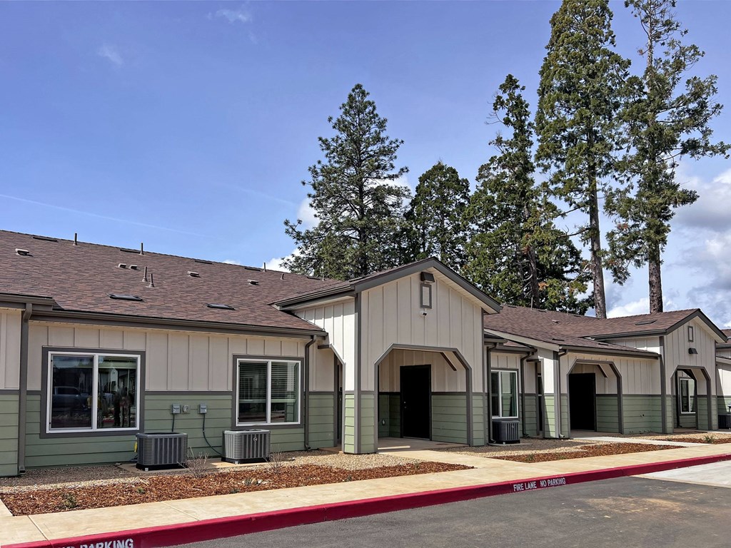 A row of small houses with a red curb in front.