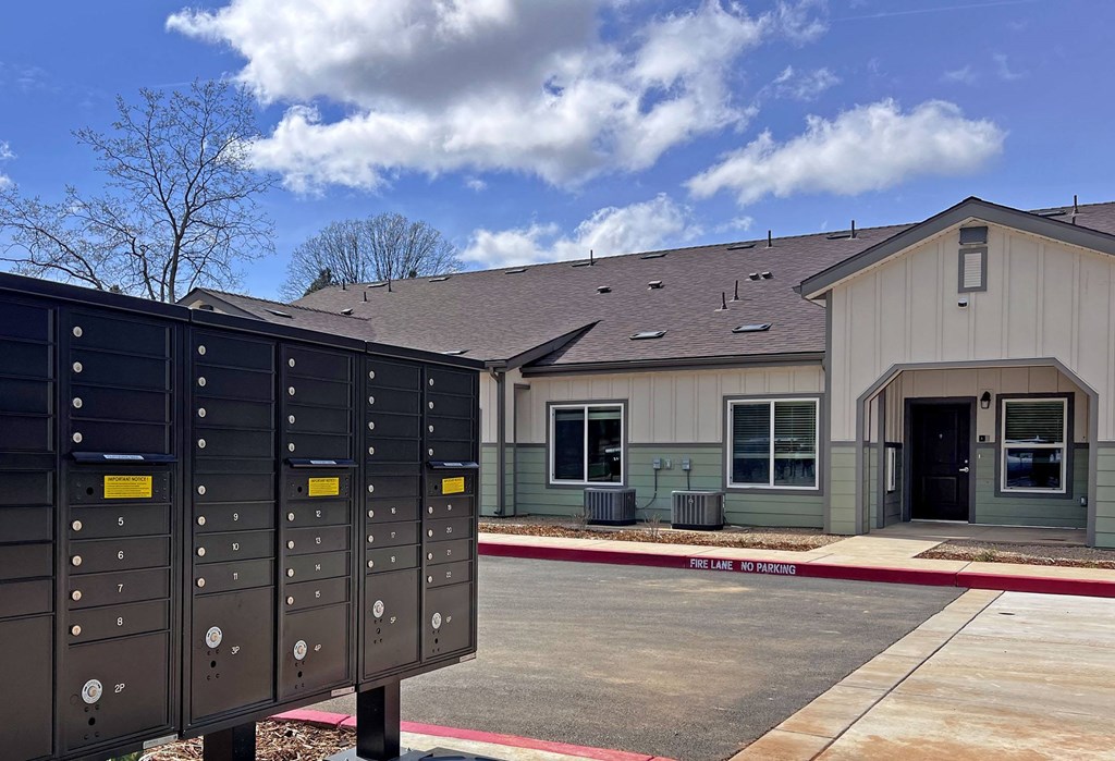 A building with a grey roof and a sign that says "No Parking" in front of it.