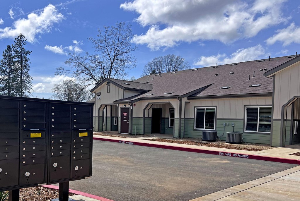 A building with a grey roof and a sign that says "No Parking" in front of it.
