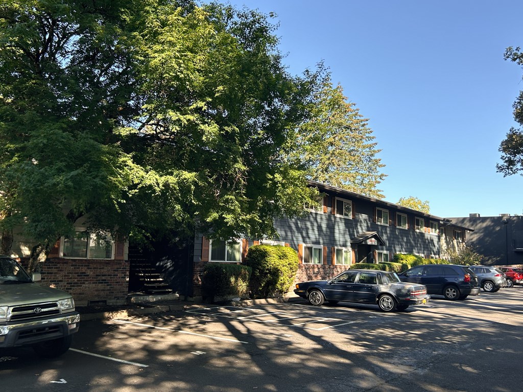 A black car is parked on the street in front of a building.