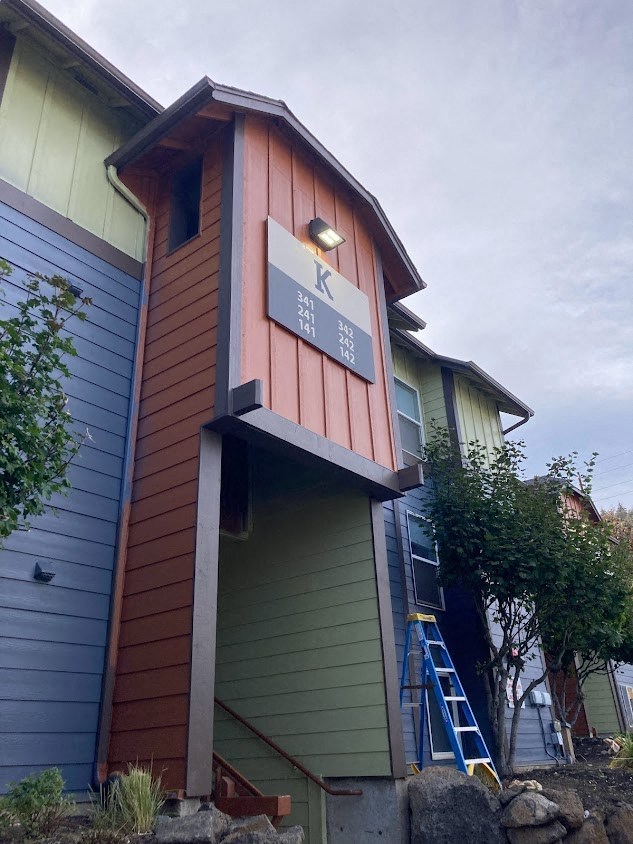 the front of a house with a sign on the side of it