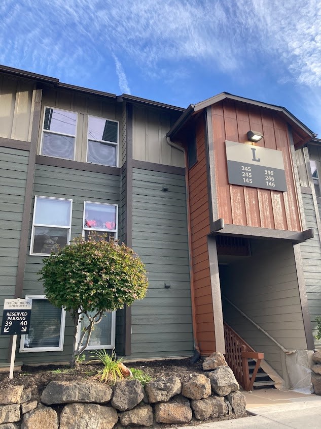 a green and brown house with a sign on the front