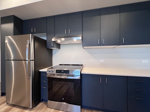A modern kitchen with a stainless steel refrigerator and oven.
