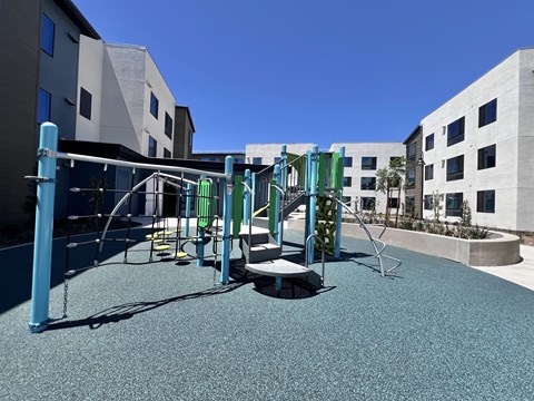 A playground with a blue and green swing set.
