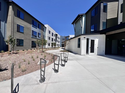 A sunny day at a modern apartment complex with a clear blue sky.