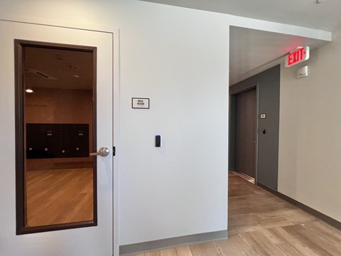 A white door with a black handle and a sign on the wall that says "EXIT".