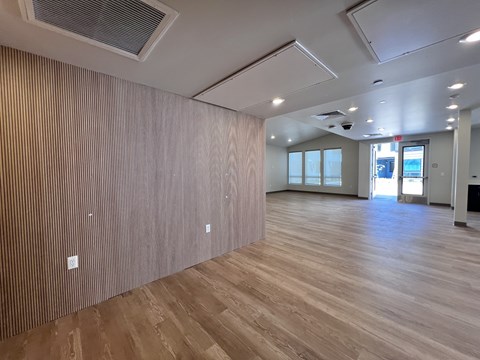 A room with wooden flooring and a wall covered in wood paneling.