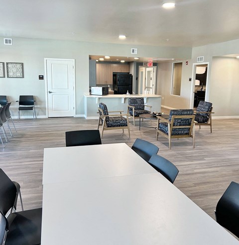 a room with a table and chairs and a kitchen
