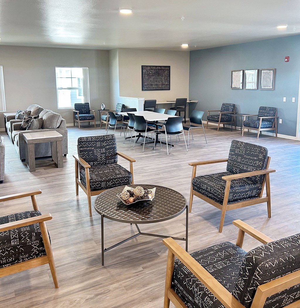 a living room with chairs and tables and a dining room