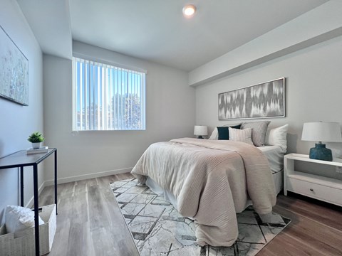 A bedroom with a large bed and a window.