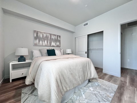 A bedroom with a large bed and a painting above it.