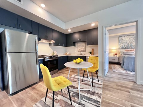 A modern kitchen with a yellow chair and a round table.