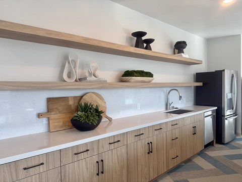 A kitchen with wooden cabinets and a black refrigerator.