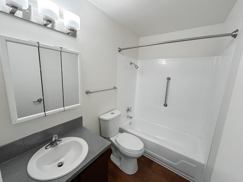 A white toilet sits next to a white sink in a small bathroom.
