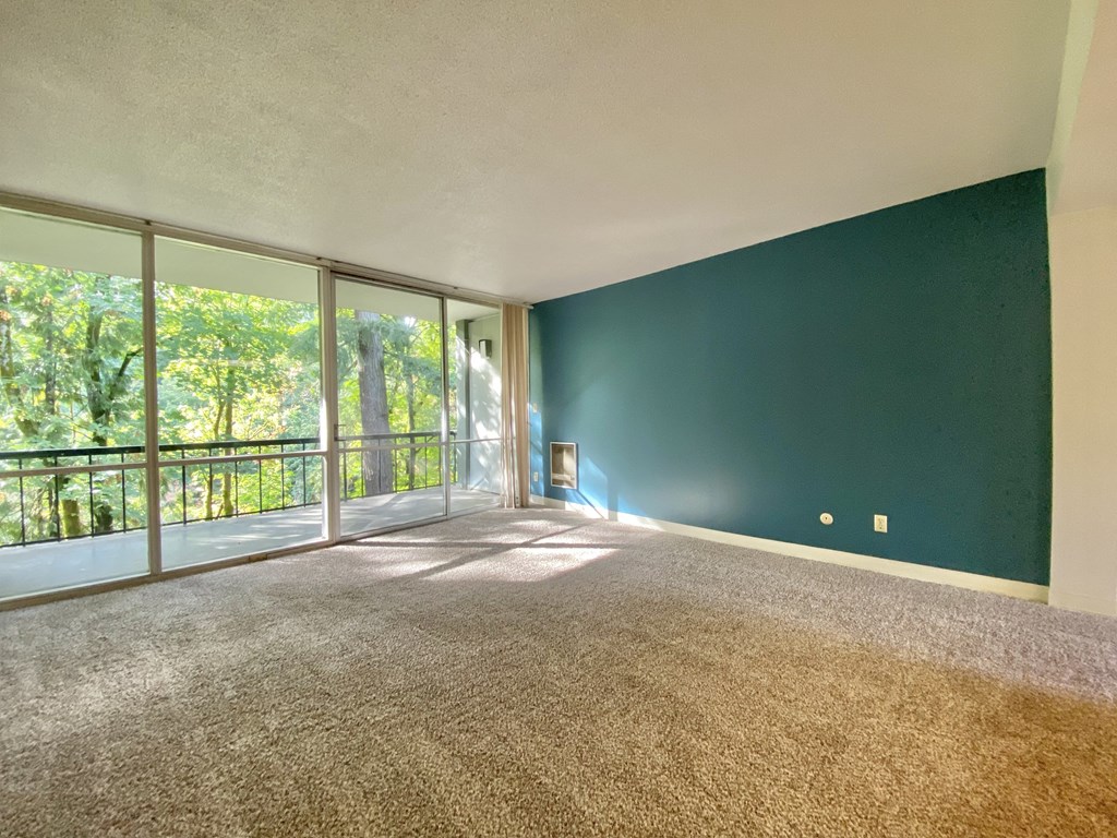 an empty living room with a balcony and a green wall