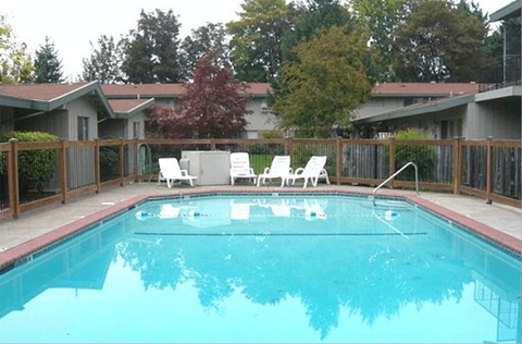 a large pool with chairs and a fence around it