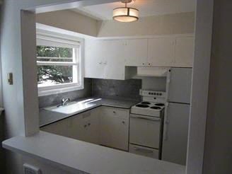 a kitchen with a stove and a sink and a window