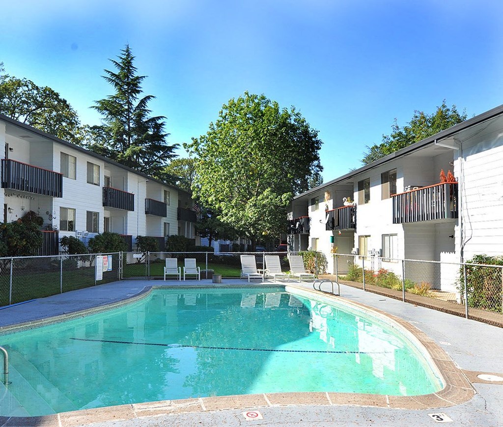 a large swimming pool in front of an apartment building