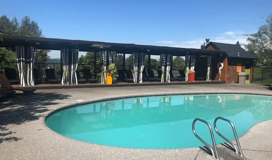 a swimming pool with a house in the background